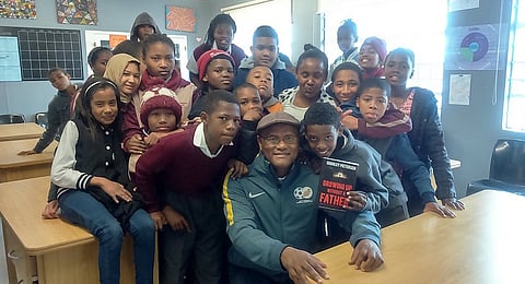 Charley Pietersen surrounded by school kids.