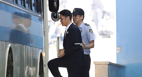 Jay Y. Lee, co-vice chairman of Samsung Electronics Co., front, is escorted by a prison officer as he boards a bus at the Seoul Central District Court in Seoul, South Korea, on Friday, Aug. 25, 2017. Lee was convicted of bribery and sentenced to five years in prison, a blow to the heir apparent of the world's biggest maker of smartphones and memory chips. Photographer: Chung Sung-Jun/Pool via Bloomberg