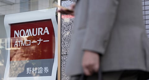 A pedestrian walks past signage displayed at a Nomura Securities Co. branch, a unit of Nomura Holdings Inc., in Tokyo, Japan, on Thursday, Oct. 27, 2016. Nomura's second-quarter profit jumped 31 percent as trading income made up for a slump in its retail brokerage business. Photographer: Kiyoshi Ota/Bloomberg