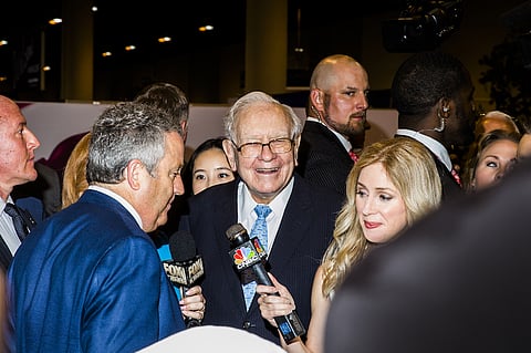Warren Buffett, chairman and chief executive officer of Berkshire Hathaway Inc., center, tours the shopping floor ahead of the Berkshire Hathaway annual meeting in Omaha, Nebraska, U.S., on Saturday, May 5, 2018. The rules, which require Berkshire to report unrealized gains or losses in equity investments in net income, helped fuel a $1.14 billion loss at Buffett's Berkshire Hathaway Inc. in the first quarter. Photographer: David Williams/Bloomberg