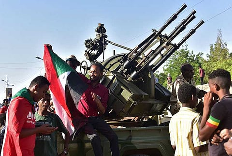 Young Sudanese sit atop a military vehicle as they celebrate after an announcement made by Sudan's new military ruler, in the Sudanese capital Khartoum, on April 13, 2019.  Photographer: Ahmed Mustafa/AFP/Getty Images