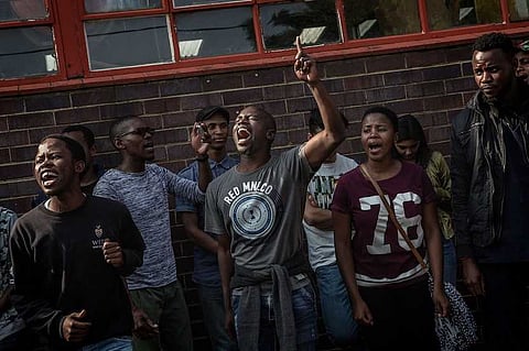 Students protesting for free high education sing and dance in support of arrested leader Mcebo Dlamini at Cleveland Police station on October 16, 2016 in Johannesburg. Photographer: Gianluigi Guercia/AFP/Getty Images