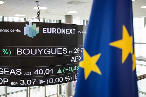 Stock price information is displayed on a screen as a European Union (EU) flag hangs inside the Euronext NV Paris stock exchange in La Defense business district of Paris, France, on Wednesday, Jan. 16, 2019. European investors shook off the rejection of U.K. Prime Minister Theresa May’s Brexit deal in parliament ahead of a confidence vote, opening higher after mixed markets in Asia, and gains in the U.S. Photographer: Christophe Morin/Bloomberg