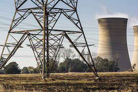 Electrical power lines hang from a transmission pylon as the cooling towers of the Eskom Holdings SOC Ltd. Hendrina coal-fired power station stand beyond in the town of Pullen's Hope, Mpumalanga, South Africa, on Wednesday, June 12, 2019. Air pollution in the biggest towns in Mpumalanga is regularly higher than that in Beijing and Jakarta, two of the most polluted cities in the world, according to AirVisual, an air-quality monitoring app. Photographer: Waldo Swiegers/Bloomberg