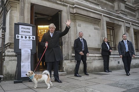 Boris Johnson, U.K. prime minister and leader of the Conservatives Party, with his dog Dilyn, gestures after casting his vote in the U.K. general election at a polling station in London, U.K., on Thursday, Dec. 12, 2019. The U.K. votes on Thursday to determine whether Johnson gets the mandate he wants to "get Brexit done," or Labour Party Leader Jeremy Corbyn replaces him in 10 Downing Street to pursue his "radical agenda" of wealth redistribution and nationalizations. Photographer: Chris Ratcliffe/Bloomberg