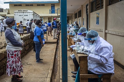 Health workers personal protective equipment (PPE) record the details of residents, as they stand at social distance to each other, during a Covid-19 testing drive at Olympic Primary School in Nairobi, Kenya, on Tuesday, May 26, 2020. Halfway through Kenyan President Uhuru Kenyatta’s second term his pledge of transforming the economy through manufacturing, farming, health care and low-cost housing have been slow to show results, and the coronavirus pandemic could now reduce that to little more than an election promise. Photographer: Patrick Meinhardt/Bloomberg
