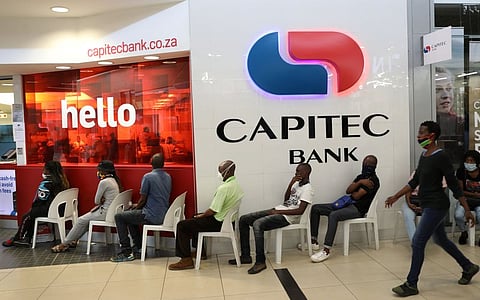 Customers sit on plastic chairs outside Capitec bank at a mall as South Africa starts to relax some aspects of a stringent nationwide the coronavirus disease (COVID-19) lockdown in Soweto, South Africa May 5, 2020. REUTERS/Siphiwe Sibeko
