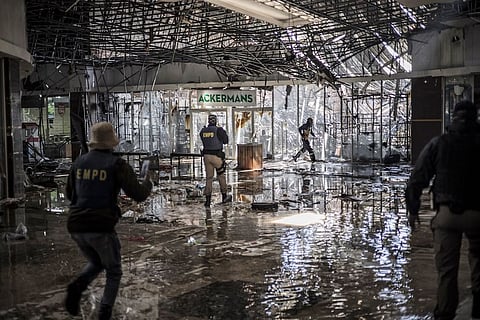 A suspected looter fired upon with rubber bullets by Ekurhuleni Metro Police Department officers (EMPD) on patrol inide a flooded mall in Vosloorus, on July 13, 2021. Photographer: Marco Longari/AFP/Getty Images