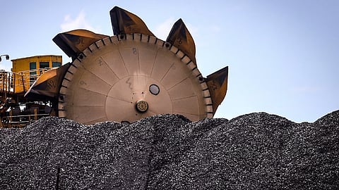 An excavator on a pile of coal. Photographer: Bloomberg Creative Photos/Bloomberg Creative Collection
