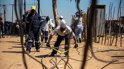 DIEPSLOOT, SOUTH AFRICA - SEPTEMBER 29: Eskom workers together with SAPS, JMPD and the security company Red Ants cutting illegal connections during the launch of the energy management and losses campaign in Gauteng on September 29, 2020 in Diepsloot, South Africa. According to Eskom illegal connections are a leading cause of network overloading and repeated transformers and mini substations failure. (Photo by Gallo Images/Alet Pretorius)
