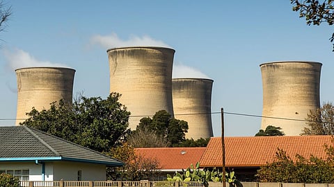 Emissions rise from the cooling towers of the Eskom Holdings SOC Ltd. Hendrina coal-fired power station from beyond residential housing in the town of Pullen's Hope, Mpumalanga, South Africa, on Wednesday, June 12, 2019. Air pollution in the biggest towns in Mpumalanga is regularly higher than that in Beijing and Jakarta, two of the most polluted cities in the world, according to AirVisual, an air-quality monitoring app. Photographer: Waldo Swiegers/Bloomberg