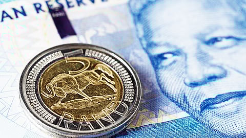 Five Rand coin rests on new Mandela South African banknote. Getty Images