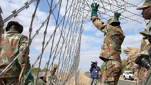 MUSINA, SOUTH AFRICA ñ 17 August 2010: Soliders repair the fence on the border line between Zimbabwe and South Africa, at Musina in the Limpopo Province, South Africa on 17 August 2010. Some parts of the fence were cut through. Members of the South African Defence Force (SADF) took the media to view the state of the border. (Photo by Gallo Images/Daily Sun/Thabo Ramookho)