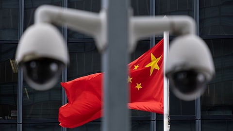 The flag of China is flown behind a pair of surveillance cameras outside the Central Government Offices in Hong Kong, China, on Tuesday, July 7, 2020. Hong Kong leader Carrie Lam defended national security legislation imposed on the city by China last week, hours after her government asserted broad new police powers, including warrant-less searches, online surveillance and property seizures. Photographer: Roy Liu/Bloomberg