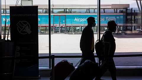 Passengers wheel their luggage inside the departures terminal at Cape Town International Airport in Cape Town, South Africa, on Friday, Dec. 3, 2021. South Africa announced the discovery of a new variant, later named omicron, on Nov. 25 as cases began to spike and the strain spread across the globe, with many countries halting flights to and from southern Africa. Photographer: Dwayne Senior/Bloomberg