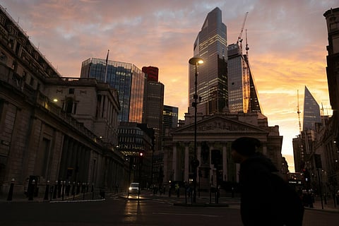 A commuter passes the Royal Exchange and the Bank of England (BOE) in the City of London, UK, on Monday Oct. 3, 2022. Traders are the most negative ever on the pounds prospects, even after the UK government scrapped one of its new tax policies, a sign it will take a bigger policy U-turn to restore credibility with markets. Photographer: Carlos Jasso/Bloomberg