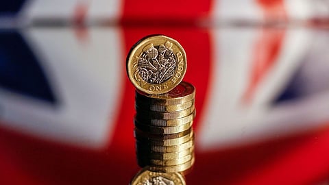 A stack of one pound sterling coins sit in front of a British Union flag, also known as a Union Jack, in this arranged photograph in London, U.K., on Wednesday, Oct. 14, 2020. Pound traders are remarkably nonchalant even as U.K. Prime Minister Boris Johnson's self-imposed deadline of Oct. 15 to get a trade deal with the European Union looms large. Photographer: Hollie Adams/Bloomberg