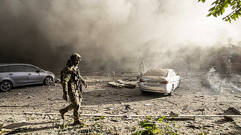Firefighters and Ukrainian soldiers conduct work after the Russian drone attacks in Kyiv, Ukraine on October 17, 2022. At least 4 separate explosions were heard in Kyiv, while authorities reported that the attacks were carried out with kamikaze drones. (Photo by Metin Aktas/Anadolu Agency via Getty Images)