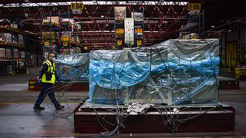 A worker passes wrapped cargo in the Air France-KLM G1XL cargo hangar at Charles de Gaulle airport in Roissy, France, on Monday, May 10, 2021. European Union leaders urged U.S. President Joe Biden to lift restrictions on exports of Covid-19 vaccines to address the desperate needs of developing countries before embarking on complex discussions about whether patent waivers might also boost supply in the longer term.