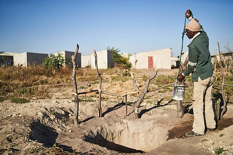 A resident hoists a bucket of water from a well to water his garden in Bulawayo, Zimbabwe, on Thursday, June 23, 2022. After more than a century of planning Zimbabwes second-biggest city is about to see a resolution to water shortages that have left the settlement of 666,000 people without supply for as long as four days at a time. Photographer: Godfrey Marawanyika/Bloomberg