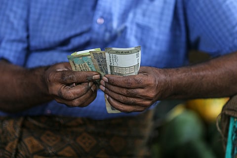 A vegetable vendor counts Indian rupee banknotes at a vegetable market in Mumbai, India, on Wednesday, July 20, 2022. The rupee slid to all-time low of 80.06 per dollar on Tuesday, and has lost 2.4% over the past month, the third-worst performing Asian currency over the period. Photographer: Dhiraj Singh/Bloomberg