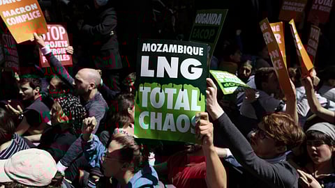 Environmental activists hold up placards and form a human chain while protesting outside the venue of the TotalEnergies SE annual general meeting in Paris, France, on Wednesday, May 25, 2022. Climate activists disrupted the meeting by blocking the entrance to denounce the company's environmental policies and stake in Russia despite Moscow's war in Ukraine. Photographer: Benjamin Girette/Bloomberg