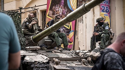 Members of Wagner group sit atop of a tank in a street in the city of Rostov-on-Don, on June 24. Photographer: Roman Romokhov/AFP/Getty Images