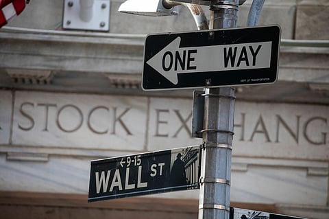 A Wall St. sign in front of the New York Stock Exchange (NYSE) in New York, US, on Monday, March 20, 2023. Stocks rebounded as regulators worldwide rushed to shore up market confidence over the weekend, with the recent financial turmoil spurring speculation on a slower pace of tightening from major central banks.
