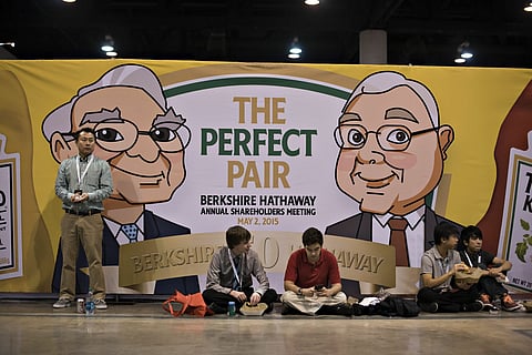 Caricatures of Warren Buffett, Berkshire Hathaway Inc. chairman and chief executive officer, and Charles Munger, vice chairman of Berkshire Hathaway Inc., appear on a sign advertising a special edition package of Heinz ketchup and mustard during the Berkshire Hathaway Inc. annual shareholders meeting in Omaha, Nebraska, U.S., on Saturday, May 2, 2015. More than 40,000 people are expected Saturday at the Berkshire Hathaway annual meeting, which marks Warren Buffett's 50th year running the company.