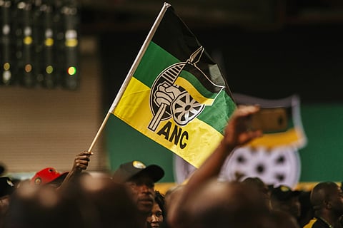 A delegate waves an ANC flag.