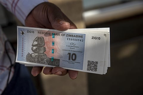 A customer displays a bundle of brand new ZiG banknotes after collecting them from a bank in Harare, Zimbabwe, on Tuesday, April 30, 2024. The southern African nation thats had bouts of hyperinflation and triple-digit inflation introduced ZiG, short for Zimbabwe Gold on April 5. Photographer: Cynthia R Matonhodze/Bloomberg