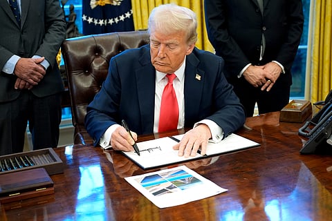 Donald Trump signs an executive order in the Oval Office on Feb. 25. Photographer: Yuri Gripas/Abaca/Bloomberg