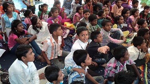 Labourers’ children watch a movie