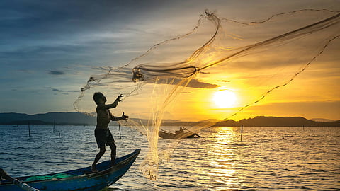 A tranditional fisherman casts his net wide for a catch