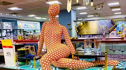 An ‘evolved’ mannequin leans languidly amid crystal and curios curated to spur consumerism