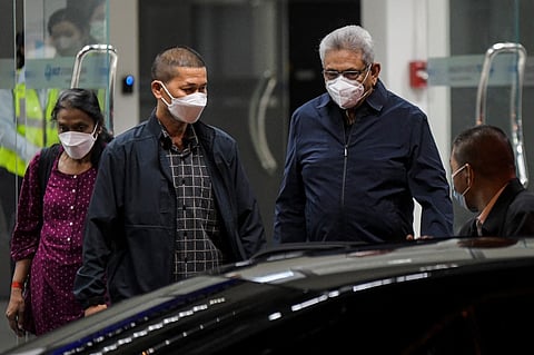 Former Sri Lankan president Gotabaya Rajapaksa (2nd R) walks toward a vehicle upon his arrival at Don Mueang International Airport in Bangkok on August 11, 2022. - Rajapaksa on August 11 left Singapore where he had taken refuge following his escape from protesters at home, after he was given a visa only for about a month in the city-state. Photo by Tananchai KEAWSOWATTANA / THAI NEWS PIX / AFP