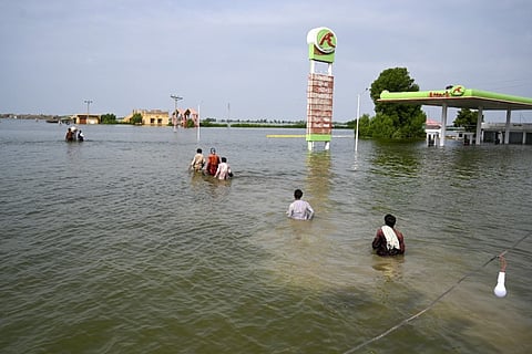 AAMIR QURESHI/AGENCE FRANCE-PRESSE
DISPLACED people wade through floodwaters to return home after heavy monsoon rains in Dadu district, Sindh province, Pakistan.