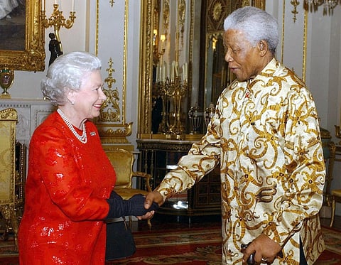 In this file photo taken on October 20, 2003 Britain's Queen Elizabeth II (L) meets with former South African President Nelson Mandela (R) during a reception at Buckingham Palace in London to mark the centenary of the Rhodes Trust. - From a string of US presidents to Lady Gaga, Queen Elizabeth II met leading political and artistic personalities from around the globe during her record-breaking time on the throne. Some were despised dictators, others world-famous guitarists she made polite conversation with. Regardless of the personalities, she always kept her composure. Photo by KIRSTY WIGGLESWORTH / POOL / AFP