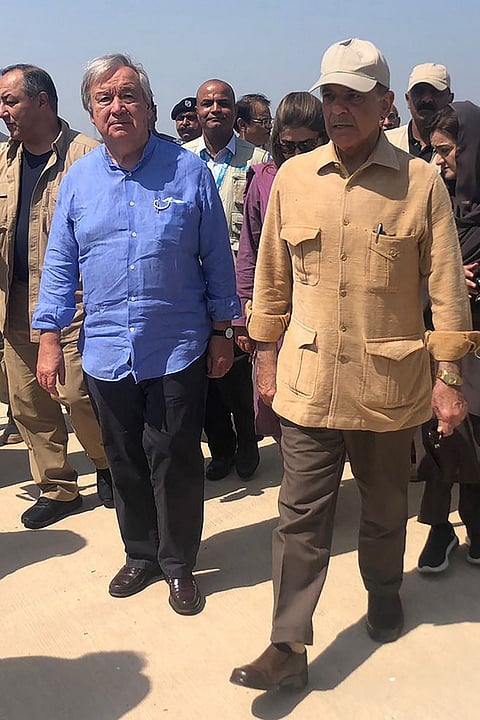 Pakistan's Prime Minister Shehbaz Sharif (R) and United Nations Secretary-General Antonio Guterres (L) arrive at the Sukkur airport during their visit to flood-affected areas in Sindh province on September 10, 2022. - United Nations Secretary-General Antonio Guterres said developing nations were paying a "horrific price" for the world's reliance on fossil fuels, as he toured parts of Pakistan hit by floods blamed on climate change. Photo by Muhammad DAUD / AFP