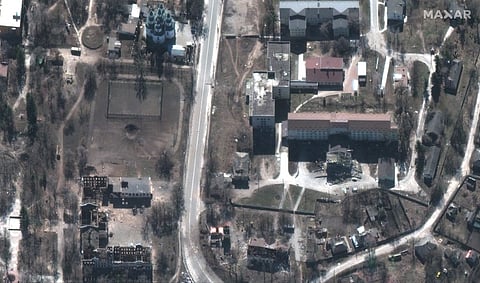 This handout satellite image released by Maxar Technologies on September 16, 2022 shows a damaged hospital and nearby buildings and Izyum, eastern Ukraine on March 24, 2022. - Ukrainian investigators descended on a pine forest outside the recaptured town of Izyum on September 16, 2022 and began pulling hundreds of hastily buried bodies from the sandy soil. At least one of the corpses had been buried with bound hands, an AFP journalist saw. Kyiv officials said they had counted 450 graves at the mass burial site and found 10 alleged "torture centres" after the Kharkiv region was recaptured from Russian invaders. Photo by Satellite image ©2022 Maxar Technologies / AFP