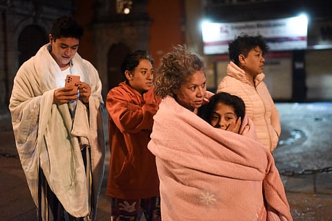Residents stand in a street after a 6.8-magnitude earthquake in Mexico City on 22 September. Photo by Pedro PARDO / AFP