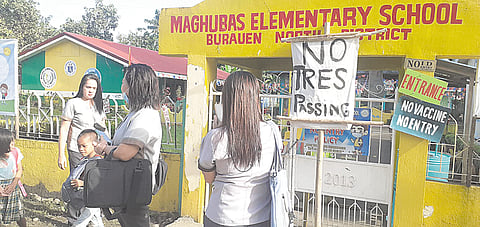 Students and teachers wait outside Maghubas Elementary School in Burauen town in Leyte on Wednesday morning after the school was padlocked due to land ownership conflicts. | PHTOGRAPH COURTESY OF GIL TAMAYO