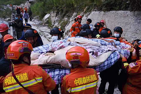 This photo taken on 5 September 2022 shows rescue workers carrying an injured person after a 6.6-magnitude earthquake in Luding county, Ganzi, in China's southwestern Sichuan province. (Photo by CNS / AFP)