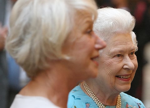 Dame Helen Mirren (left) with Queen Elizabeth II during a performing arts reception to celebrate young people at Buckingham Palace on 9 May 2011. | Dominic Lipinski / POOL / AGENCE FRANCE-PRESSE