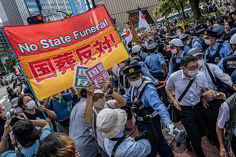 Anti-state funeral protesters demonstrate in a street near the Nippon Budokan ahead of the state funeral for former Japanese prime minister Shinzo Abe in Tokyo on 27 September 2022. (Photo by YUICHI YAMAZAKI / AFP)
