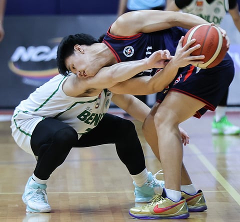 Letran’s Brent Paraiso takes the ball away from St. Benilde’s Rob Nayve in their Season 98 NCAA game yesterday at the FilOil EcoOil Centre in San Juan. The Knights won, 81-75. | Photograph by Rio deluvio for the daily tribune