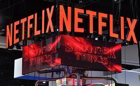 In this file photo taken on 24 July 2022, the Netflix booth advertises "Stranger Things" on a screen during Comic-Con International in San Diego, California. Netflix is expected to launch an ad-supported subscription tier in early November, about a month before rival Disney+ does the same, according to US media reports. (Photo by CHRIS DELMAS / AFP)