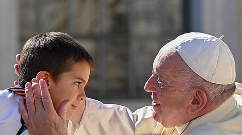 Pope Francis blesses a boy as he leaves in the popemobile car at the end of the weekly general audience on 21 September 2022 at St. Peter's Square in The Vatican. (Photo by ANDREAS SOLARO / AFP)