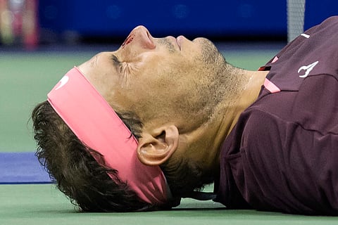 Spanish star Rafael Nadal lies on the floor to have his nose treated after accidentally hurting himself during a second-round match with Italian Fabio Fognini in the US Open. Nadal won, 2-6, 6-4, 6-2, 6-1. | COREY SIPKIN/agence france-presse