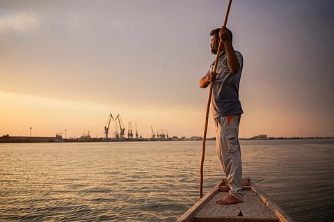 Iraqi fisherman Naim Haddad, 40, stands barefoot on his boat at sunset on Shatt al-Arab, the confluence of the Tigris and Euphrates rivers near the city of Basrah in southern Iraq, on 12 February 2022. The Tigris is one of Iraq's two big rivers that gave birth to the ancient empires of Sumer and Babylonia and are said to have watered the biblical Garden of Eden. Today, it is dying because of human activity and climate change. (Photo by AYMAN HENNA / AFP)
